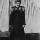 After World War II, Lorene Harrison worked as the ‘welcome hostess’ who brought gifts from Anchorage merchants to newcomers.  Here she stands in front of a tent that was the first Anchorage home of a young couple who recorded that Harrison visited them several times and brought Pepsi Cola, box candy, hand lotion, and a bouquet of carnations. 