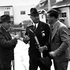 Bob Atwood shortly after his arrival in Anchorage (on right). Atwood is talking to F. C. Hanson, an engineer with the Alaska Railroad, and Jim Farley, the U. S. Postmaster General, in front of the Anchorage Post Office on Fourth Avenue.