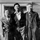 Mine' and Goro "George" Mikami with son Harry, in front of George’s Tailor Shop (4th Avenue between B and C Streets), ca. 1932.