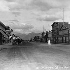 A view facing east on Fourth Avenue in Anchorage before 1934.  On the left side of the photograph is a sign for Kennedy’s Clothing, which was run by brothers Daniel and James Kennedy.  After the death of James in 1934, brother and partner Daniel moved the store across Fourth Avenue.