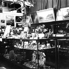 Sydney Laurence sold his paintings through a number of outlets.  In Anchorage it was Hewitt’s Drug Store; in Juneau, it was the Nugget Shop.  This photograph of the Nugget Shop shows some of his paintings on the walls.