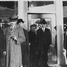Charles Bush, second from the right, dressed in a suit, stands in the doorway of a store, possibly the Brown & Hawkins store for which he was manager, mid-1920s.  The Brown & Hawkins store was one of the largest in Anchorage, and was closed due to the long economic downtown that affected Anchorage from World War I through the 1920s. 