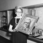 Mildred Hamill holding a portrait of prominent Anchorage artist Sydney Laurence, the only known portrait for which Laurence actually sat.  According to Hamill, Laurence asked that she do his portrait and he sat for her every morning for a week.  The painting is currently in the collection of the Anchorage Museum at Rasmuson Center. 