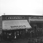 Exterior view of Z. J. Loussac’s first drug store in Anchorage, albeit obscured by a parade.