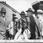 Edgar R. Tarwater, with his back to the camera, talks with a group of men, including Governor John W. Troy (Alaska territorial governor, 1933-1939).  Tarwater served as a representative in the Ninth Territorial Legislature in 1929.