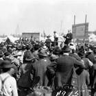 One of Andrew Christensen’s duties in 1915 was the auction of lots in the new townsite of Anchorage. Christensen held three auctions, which surprised the Alaskan Engineering Commission because of the high prices realized for the lots. Christensen is the man in the dark suit on the dais acting as auctioneer.