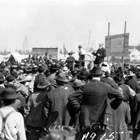 One of Andrew Christensen’s duties in 1915 was the auction of lots in the new townsite of Anchorage.  Christensen held three auctions, which surprised the Alaskan Engineering Commission because of the high prices realized for the lots.  Christensen is the man in the dark suit on the dais acting as auctioneer.